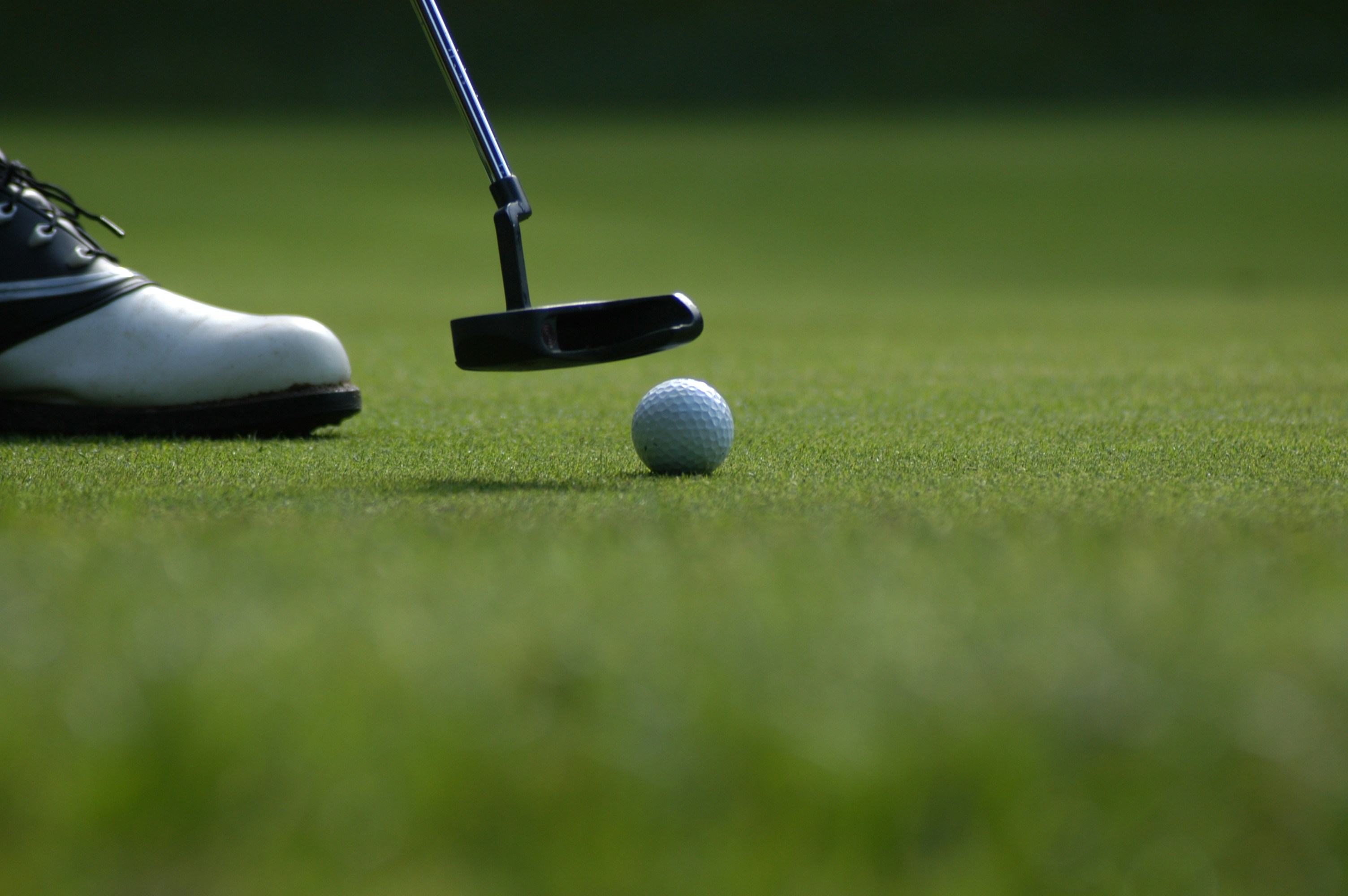 Golfer practising lag putts on a practice green