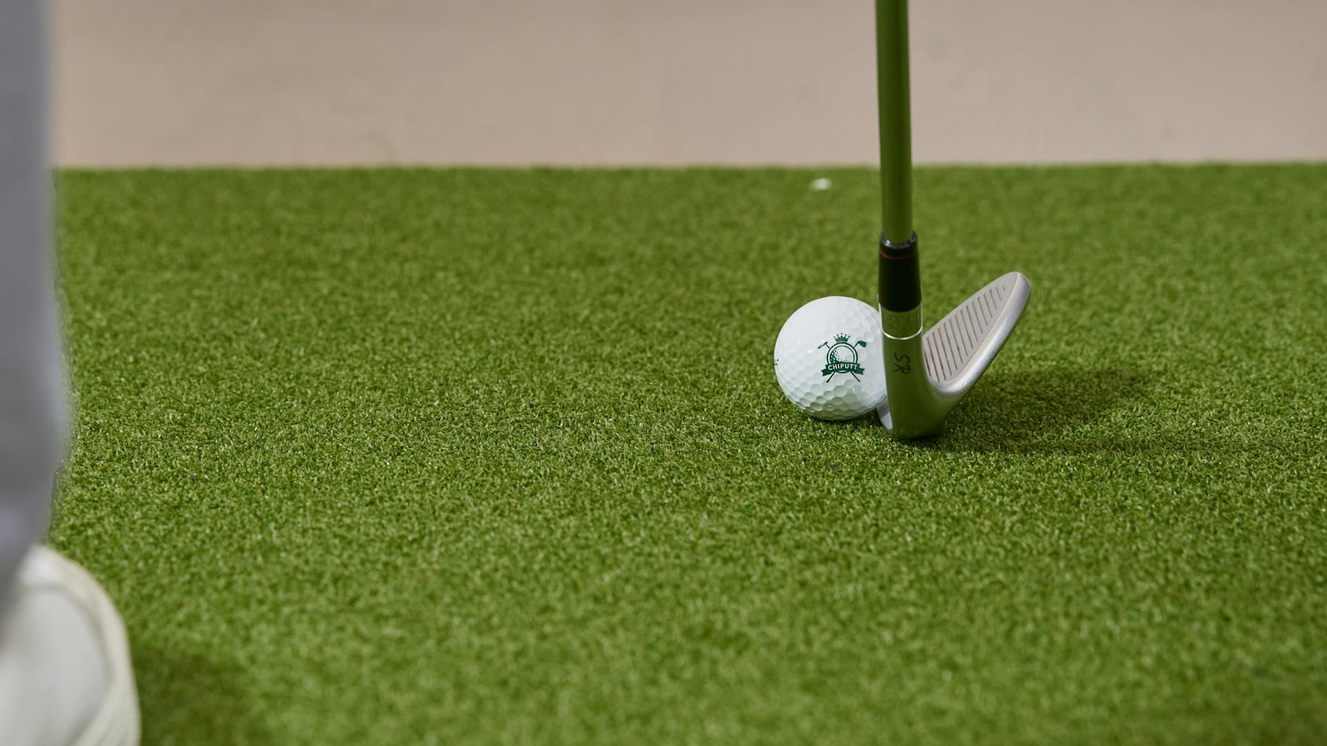 Golfer practising chip shots on a practice green